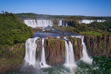 Fototapeta premium Iguazu Falls or Iguacu Falls, on the border of Argentina and Brazil, are the largest waterfall in the world. Very high waterfall with white water in beautiful rain forest landscape in the jungle