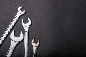 silver wrenches tools on a black background.