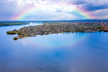 Rainbow over the river and the city. Summer landscape from above