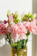 sweet pink carnation flowers in vase on a white background with text space.Beautiful fresh blooming tender carnations. mothers day, thanks design concept.
