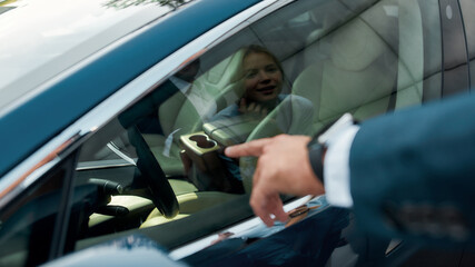 Smiling young caucasian woman reflecting in car window