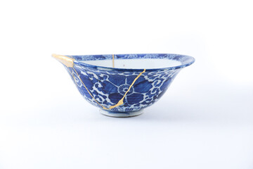 White and blue bowl , gold cracks Kintsugi, Kintsukuroi Japanese technique.