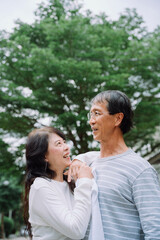 Old couple embracing at park with happiness.