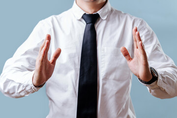 Gesticulating with his hands, the businessman holds his hands in front of him at a distance from each other. 