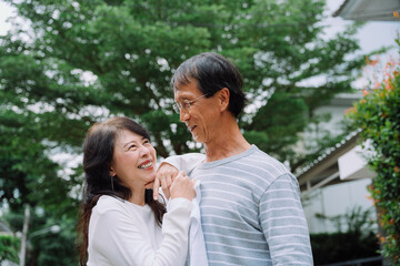 Old couple embracing at park with happiness.