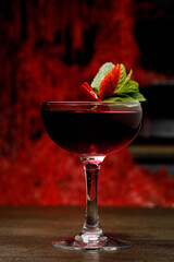 Burgundy alcoholic cocktail in a beautiful glass close up