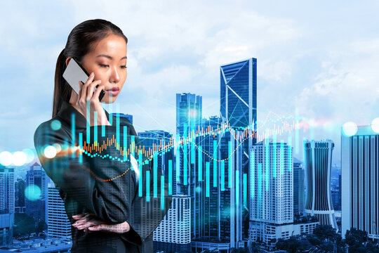 Attractive Asian businesswoman trader processing conference call to forecast the capital market behavior. Concept of trading strategy. Forex chart. Kuala Lumpur. Double exposure.