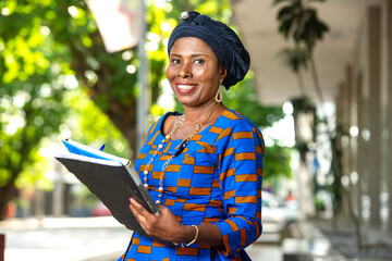 close-up of a beautiful mature african businesswoman holding document, happy.
