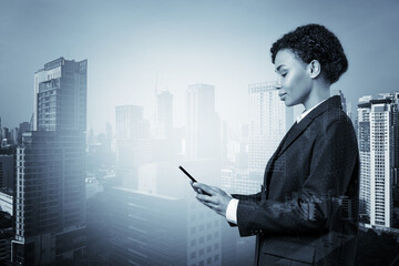 Attractive black African American business woman in suit using smart phone and thinking how to tackle the problem, new career opportunities, MBA. Bangkok on background. Double exposure.