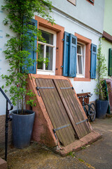 Facade of an old house in Neckargemuend, Southern germany with blue shutters an big wooden basement exit