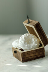 Meringue in a wooden box on a bright table close-up