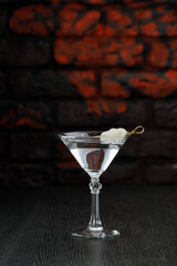 Alcoholic cocktail in a glass on a black table.