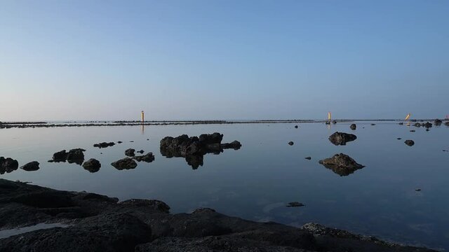 Healing video with calm sea, lighthouse, horizon, and stones.