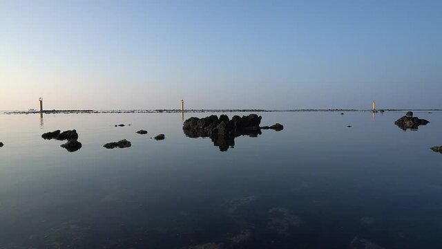 Healing video with calm sea, lighthouse, horizon, and stones.