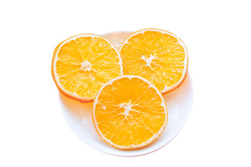 Plate with three slices of dried orange isolated on white background.