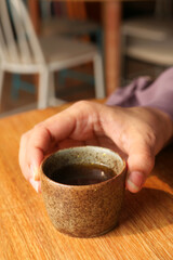 women hand holding a cup of green tea 