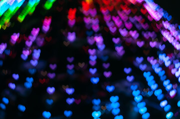 Color Bokeh on a dark background with hearts for use in graphic design