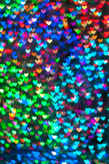 Color Bokeh on a dark background with hearts for use in graphic design