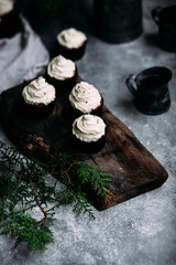 Chocolate cupcakes with creamy cream on a gray table