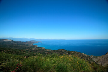 Fototapeta na wymiar A beautiful view of the island-blue sea, sky, mountains, trees and flowers.