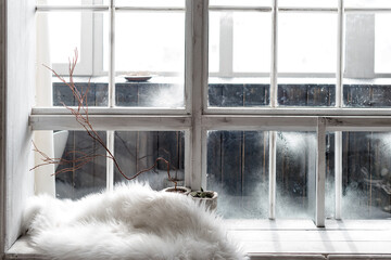Cozy winter still life. Plants in pots and warm fur on vintage windowsill. Winter season, spending winter time at cozy home concept