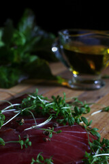 cutting board with meat and seasonings on a dark background