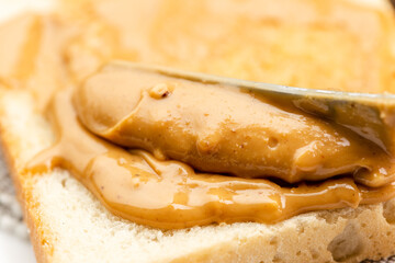 Crunchy peanut butter spreading on a toast