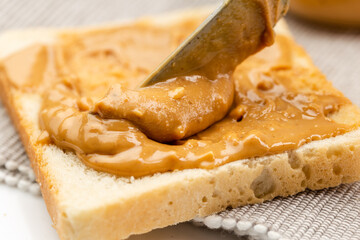 Crunchy peanut butter spreading on a toast