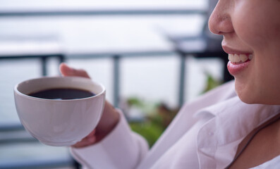 Woman drink a cup of coffee in a relaxing time. Women are happy to relax at home with hot tea or coffee. Concept of relaxation