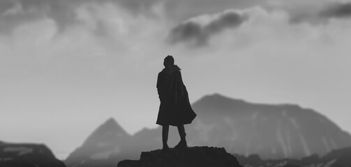 a silhouette girl in the peak of winter mountains with golden sunset b&w