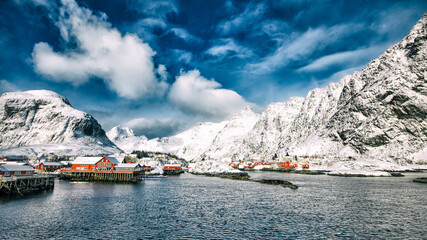 Norway. Lofoten. The village is on the water in the background of mountains and sky.