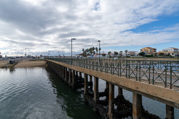 view of the old bridge leading to Faro Island and beach on the Algarve of Portugal