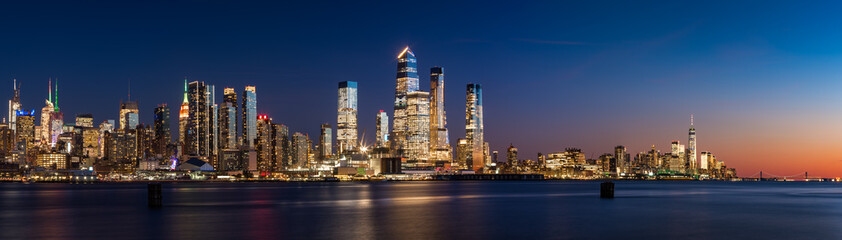 View across Hudson River of skyscrapers of New York City. Manhattan skyline at sunset from Midtown West to Lower Manhattan (Hudson Yards and World Trade Center). NY, USA - obrazy, fototapety, plakaty