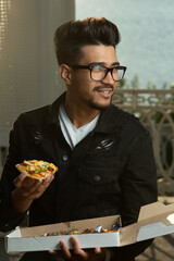 Young guy eating pizza. outside. selective focus