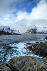 Fototapeta na wymiar Beautiful landscape. Lofoten Islands. Sea and wave against the backdrop of mountains and clouds.