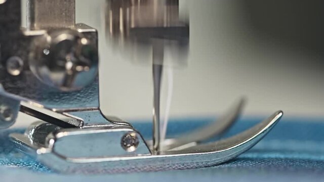 Macro of a stitch plate, foot and conveyor of the sewing machine. Working sewing machine.