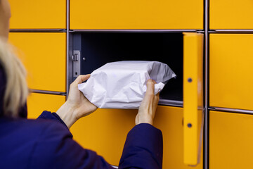 send or receive parcel with self service post terminal machine. hand with package