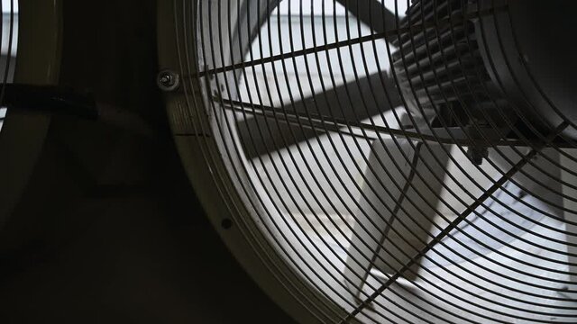 close-up view of dusty fan blades. Large fan with slow rotating blades.