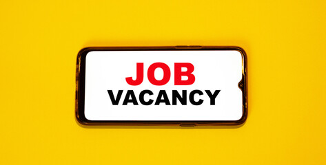 JOB VACANCY on an orange mobile phone. Job search via smartphone and tablet.