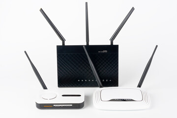 Three  Wi-Fi  routers, wireless devices with one, two and three antennas.  Black router has five...