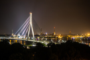 Obraz premium bridge over the river at night with city skyline