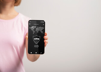 Woman holding and showing smartphone with vpn app