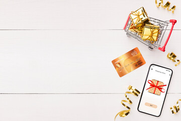 Top view of credit card, smartphone and cart with presents