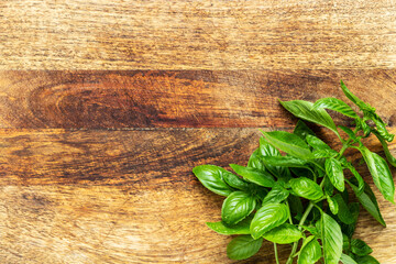 Basil twig on a vintage wood chopping board. Flat lay, top view with copy space.