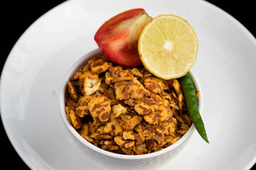 Assorted Spicy Traditional Indian Snacks Chatpata Namkeen Masala Chana Jor Zor Garam With Tangy And Aromatic Flavor. Served With Lemon Tomato And Green Chilli In White Bowl And Plate