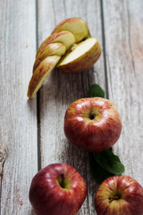 Large red apples lie on a wooden table