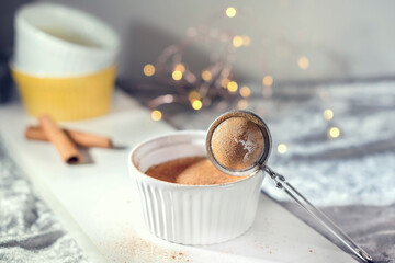 Homemade pudding with cinnamon sticks on a white background, close up