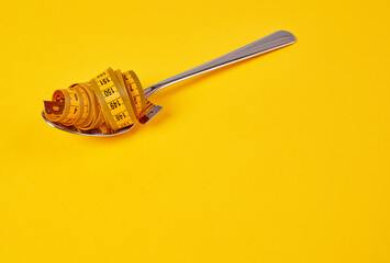 Tape measure in a spoon, diet concept