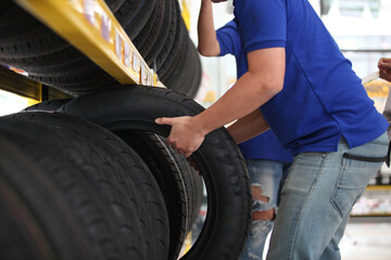 Fototapeta na wymiar Salesman with showing wheel tires at car repair service or auto store, business, maintenance and people concept