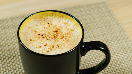 A closeup of cofee in the black cup.